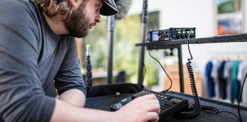 Location sound engineer using faders on F-Control to fine-tune recording on the F8n.