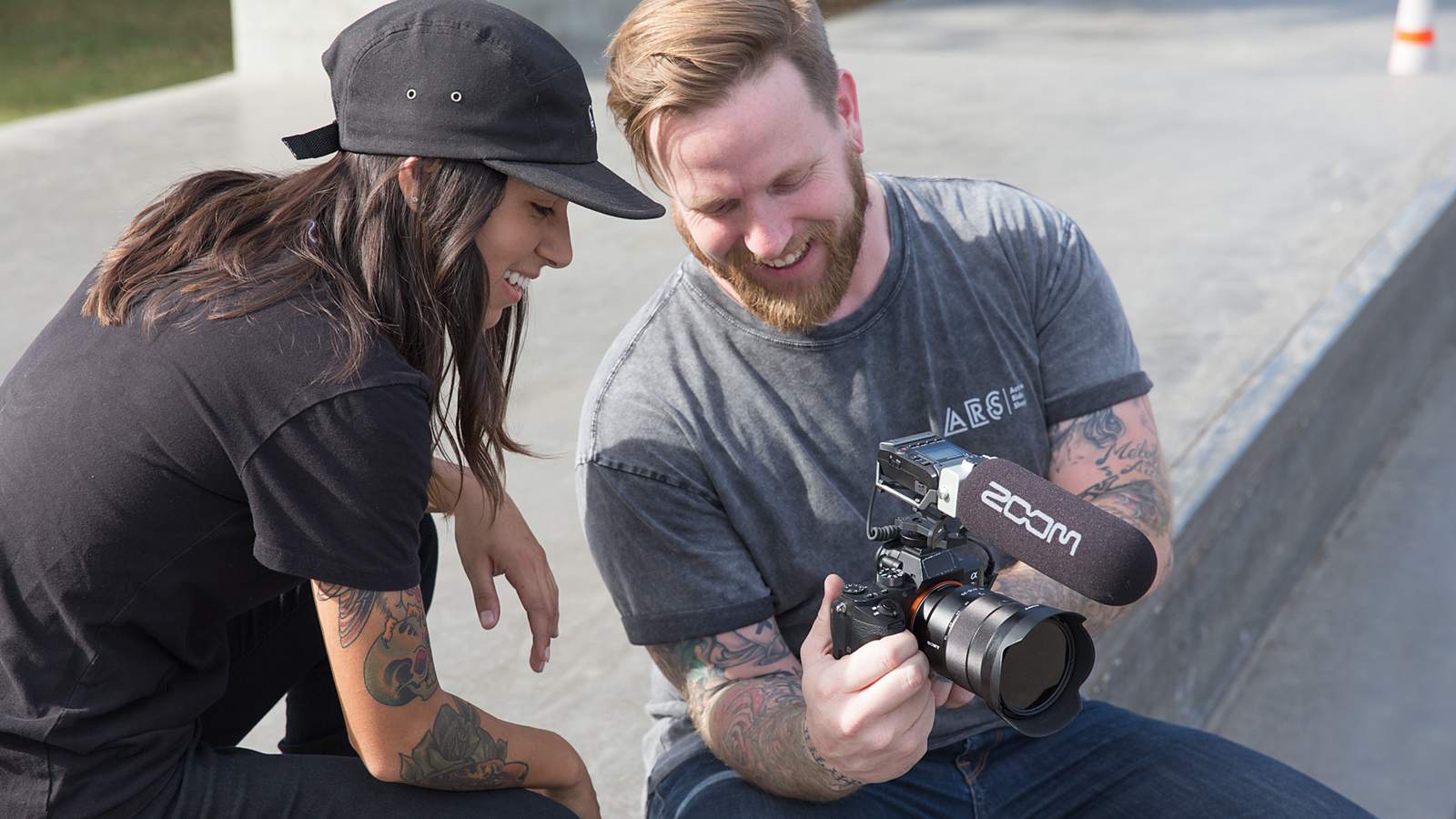 Videographer and skateboarder reviewing footage on DSLR camera with F1-SP mounted