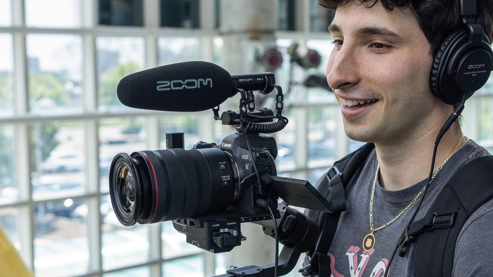 カメラリグにZOOMのオンカメラ・ショットガンマイク『ZSG-1』を取り付けて、動画撮影を行うビデオグラファー