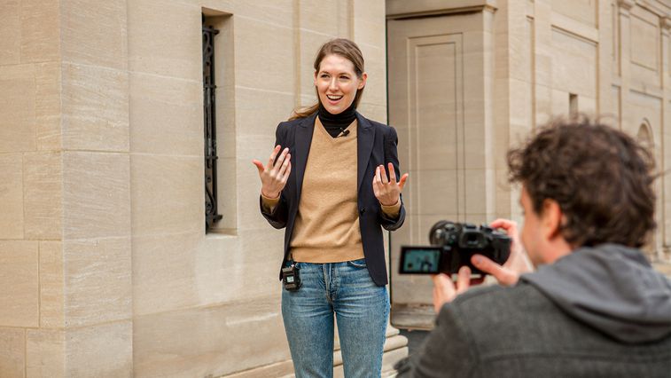 Woman being filmed outside of a building with the F1-LP attached to her waist and the lavalier connected to her collar