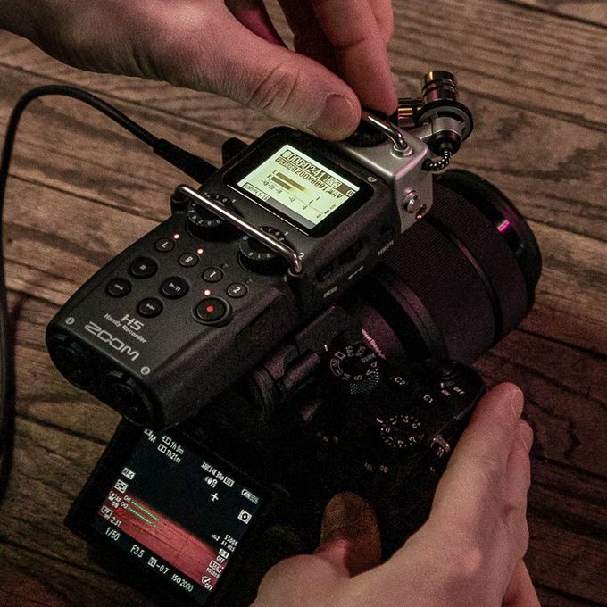 Videographer adjusting settings on H5. H5 mounted to DSLR camera.