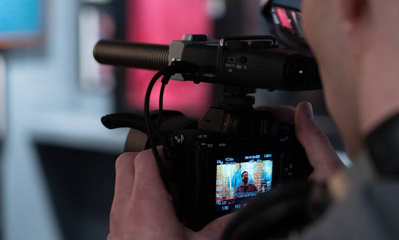 videographer recording a interview with H5 mounted to a DSLR camera