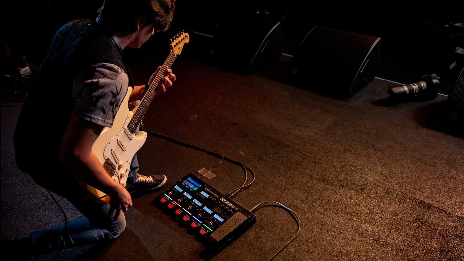 A guitarist bends over to operate the G11.