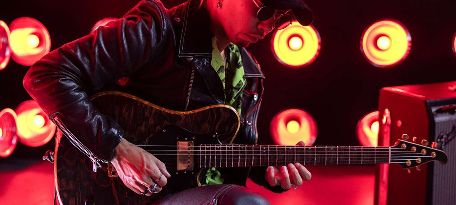 A guitarist playing the guitar on stage.