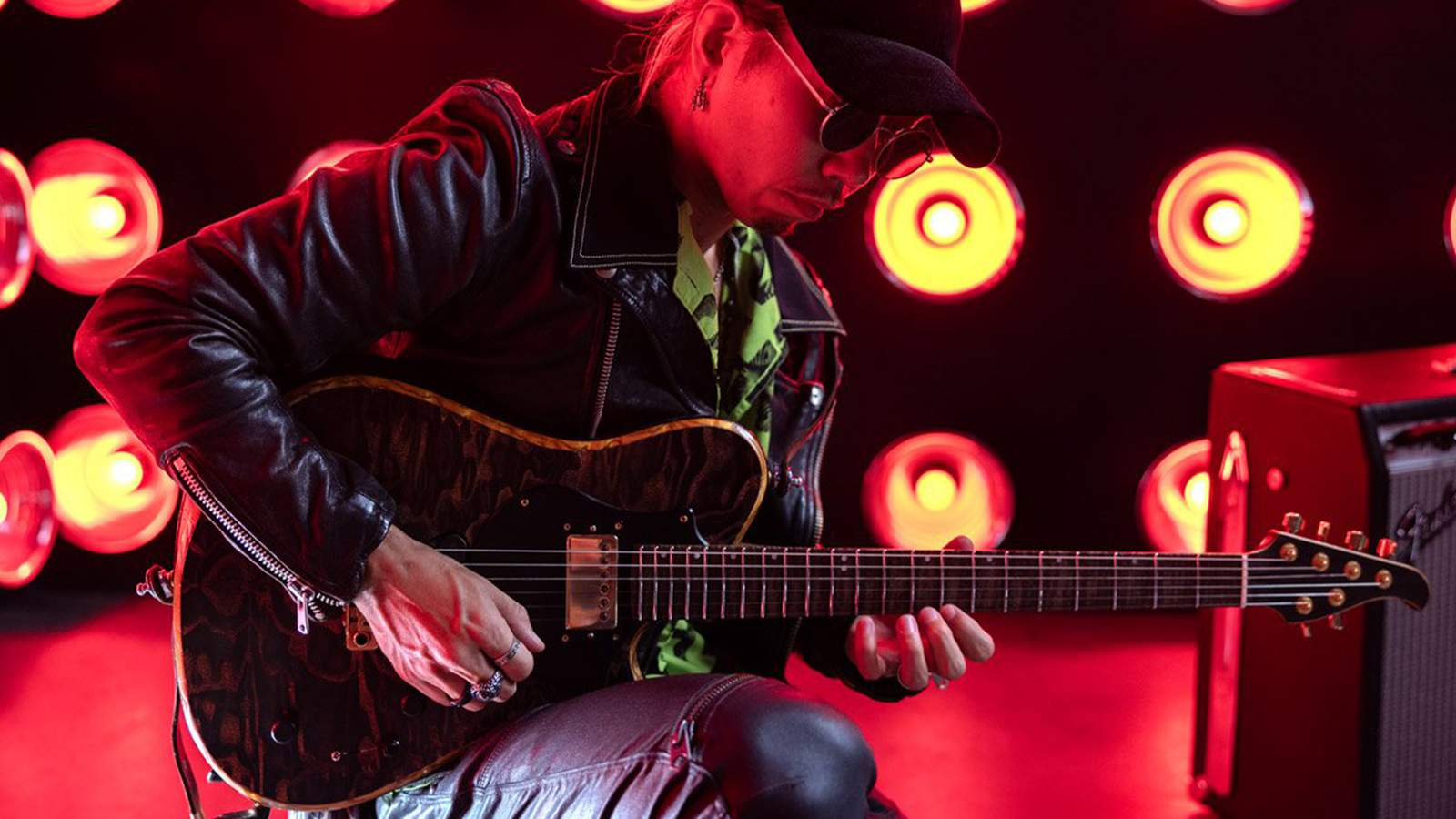 A guitarist playing the guitar on stage.