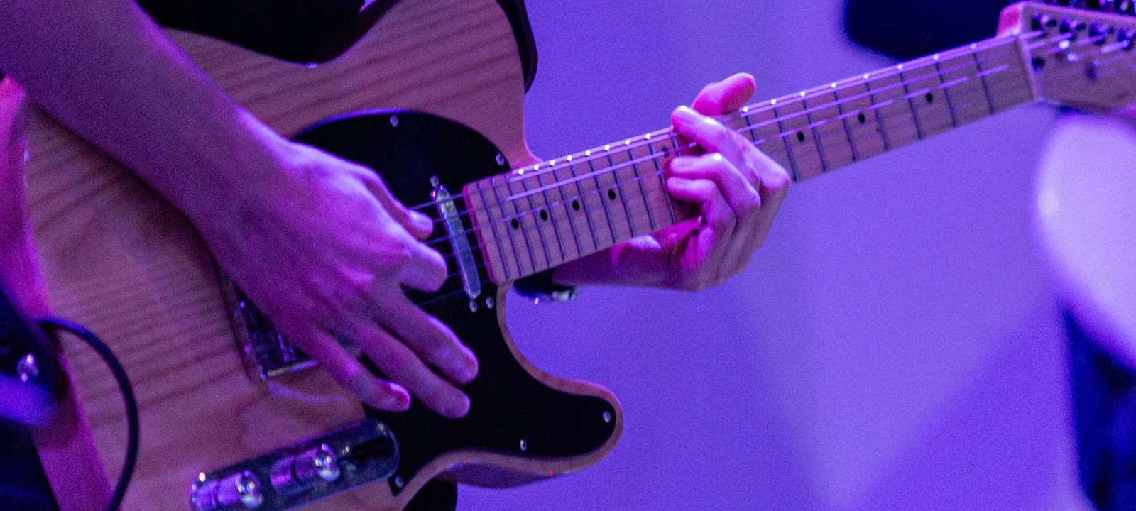 A guitarist playing the guitar on stage.