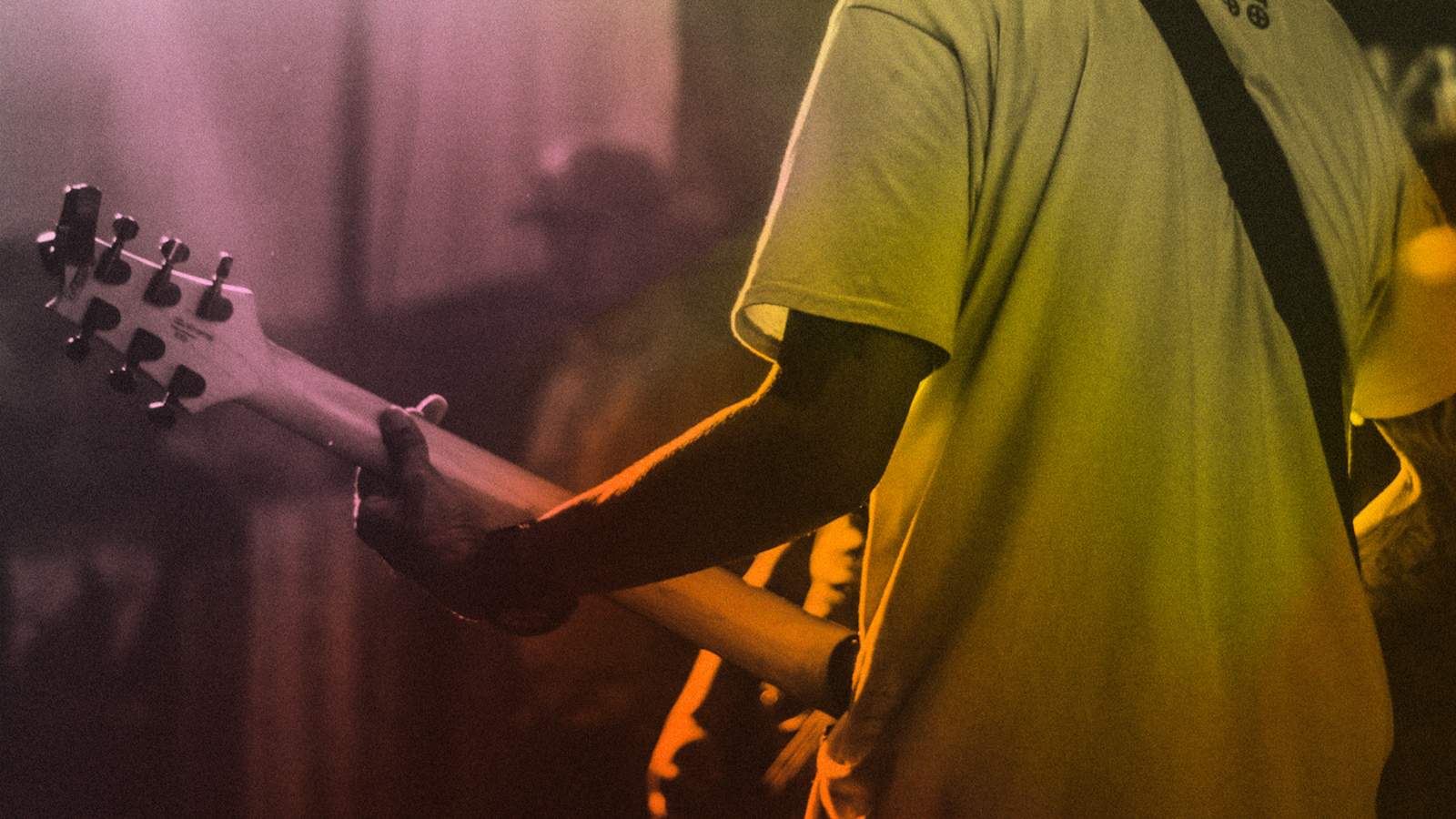 A guitarist playing the guitar on stage.
