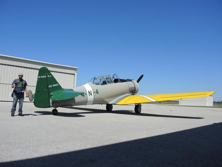 Watson Wu standing next to a plane that he will be recording audio of