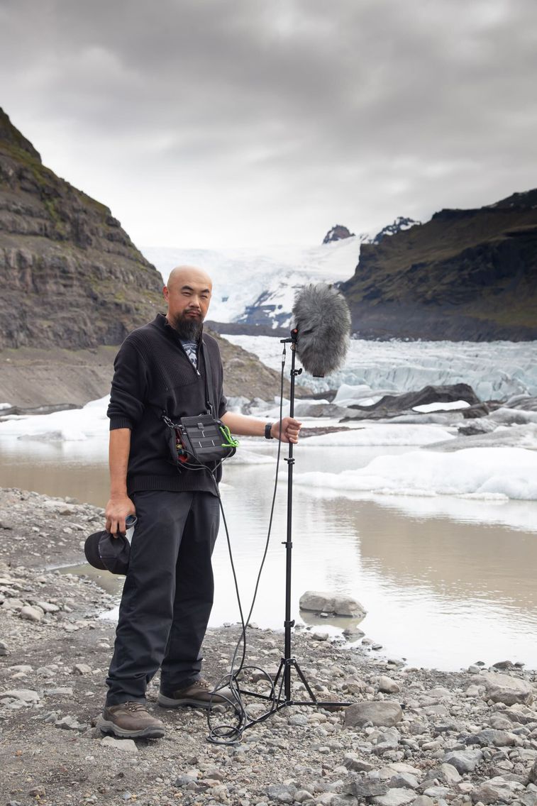 Watson Wu recording audio by a river