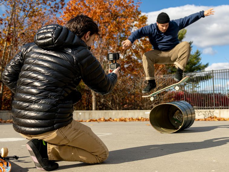 Videographer capturing skateboarder while performing a jump trick