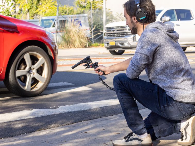 Videographer checking audio playback through headphones plugged into the M3 MicTrak