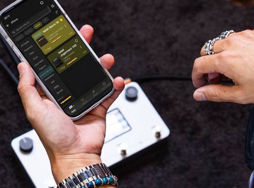 スマホ上のアプリで、NEURIG用の音色を探すギタリスト