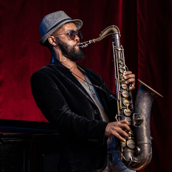 The coolest of cool cats playing the saxophone with hat