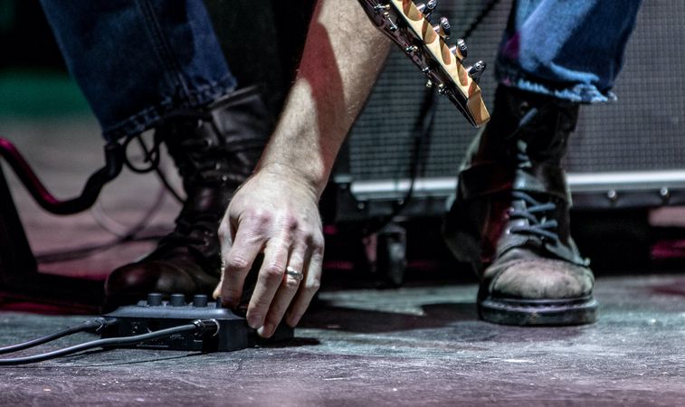 guitarist adjusting pedal