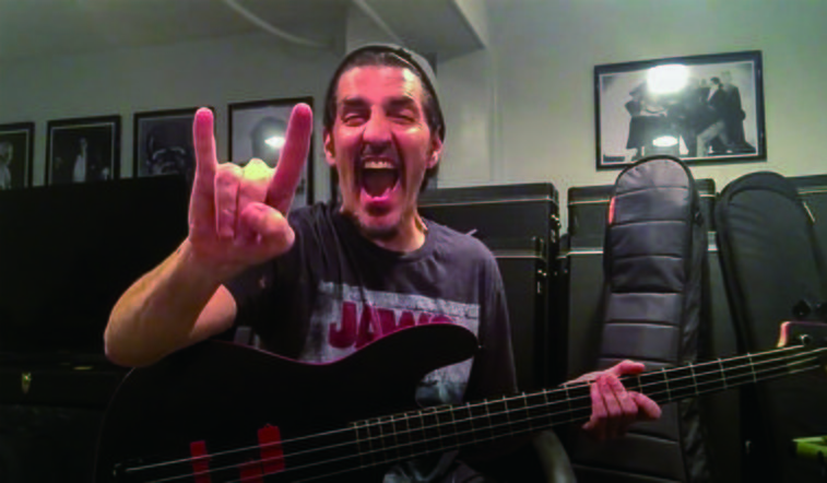 Frank Bello throwing up the horns in his home studio