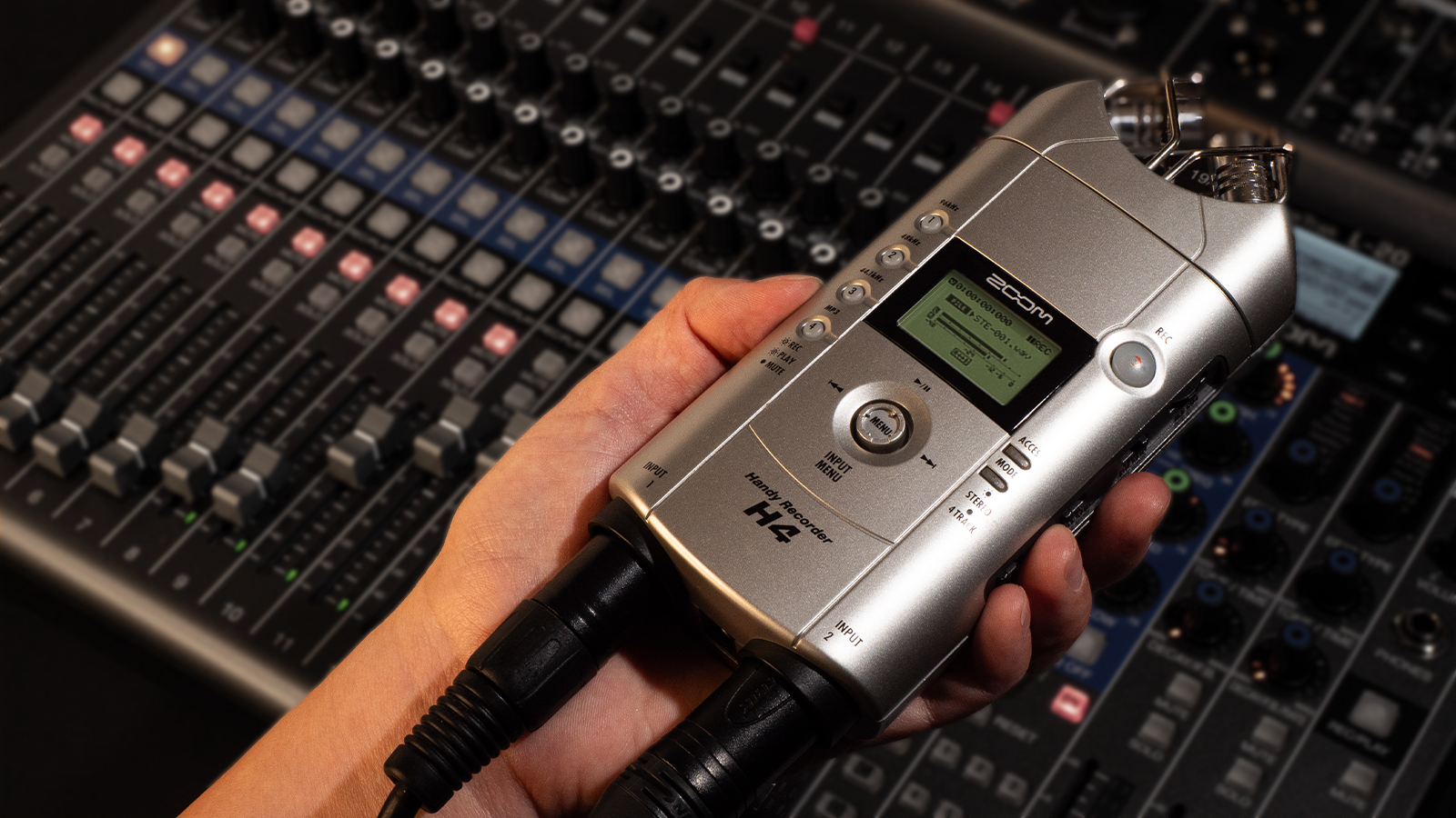 Holding the ZOOM H4, simultaneously recording the live venue's ambience with the built-in microphone and the mixer's line out via external input.