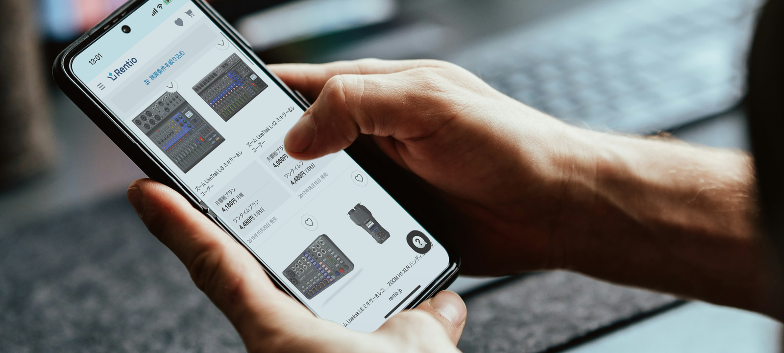 スマートフォンを操作し、ZOOM製品のレンタルを申し込んでいるところ