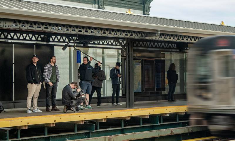 moving train with people recording video and audio. Image in gallery.